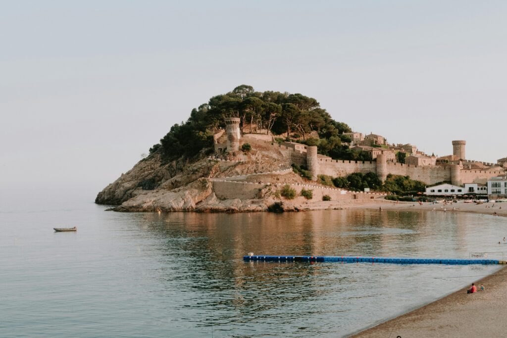 pexels photo 3049339 3049339 Beautiful view of a medieval castle on the Costa Brava coast with calm sea and sandy beach.